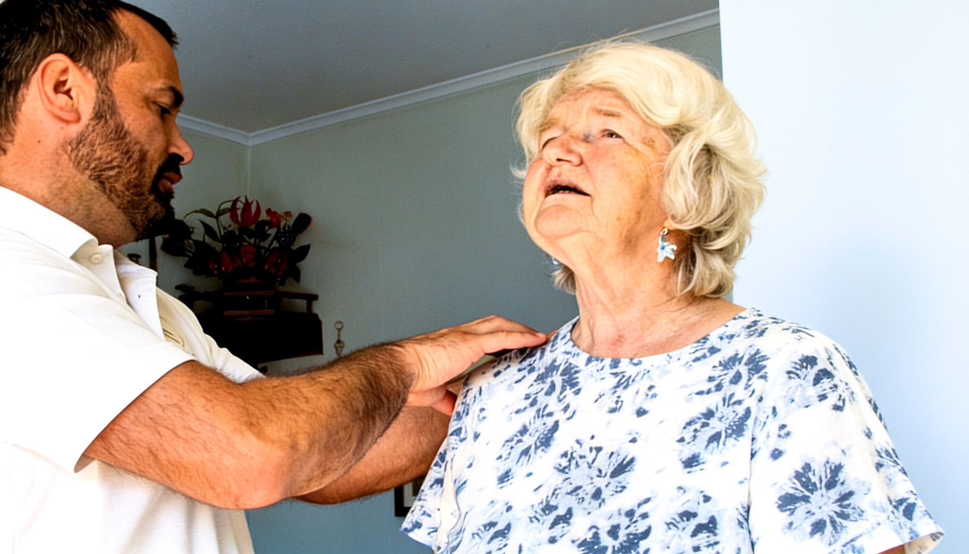 Physiotherapist treating an older patient's shoulder at home